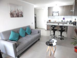ein Wohnzimmer mit einem Sofa und einer Küche in der Unterkunft hermoso departamento con vista al mar in Antofagasta