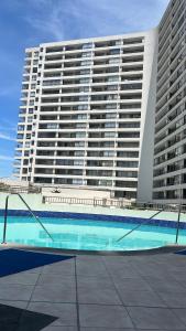 un gran edificio con una piscina frente a él en hermoso departamento con vista al mar, en Antofagasta