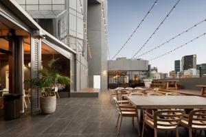 an outdoor patio with tables and chairs on a building at Hotel Grand Chancellor Brisbane in Brisbane