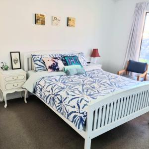um quarto com uma cama com um edredão azul e branco em Spacious Room Near Christchurch Airport em Christchurch