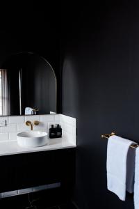 W łazience znajduje się biała umywalka i lustro. w obiekcie The Victoria Hotel Rutherglen w mieście Rutherglen