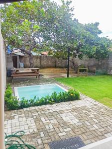 een klein zwembad in een tuin met een bankje bij Casa PHB in Parnaíba