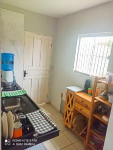 uma cozinha com um lavatório, uma janela e uma porta em Casa PHB na Parnaíba