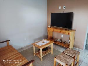 a living room with a tv and a table at Casa PHB in Parnaíba