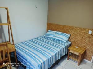 een kleine slaapkamer met een bed en een tafel bij Casa PHB in Parnaíba