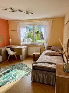 1 dormitorio con cama, escritorio y ventana en neXt doOr Donau Gästezimmer und Suite en Wurmlingen