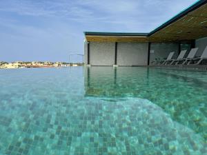 uma piscina com cadeiras na água em Ancora Punta Mita em Punta Mita