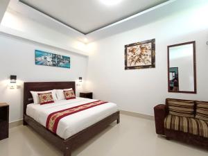 a bedroom with a bed and a mirror and a chair at La Montana Bali & Spa in Munduk
