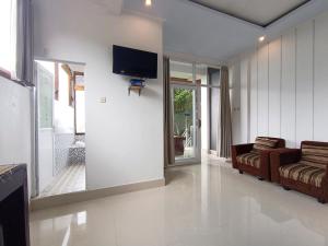 a living room with a couch and a tv on a wall at La Montana Bali & Spa in Munduk