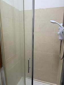 a shower with a glass door in a bathroom at Flat in Cheam in Sutton
