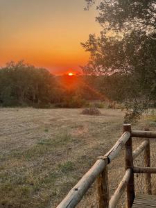 una recinzione di legno con il tramonto sullo sfondo di Monte dos Caramelos a Santiago do Cacém