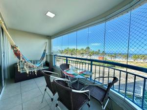 a balcony with a table and chairs and a hammock at AllMar Flats - Apartamentos frente mar - Beach Village in Fortaleza