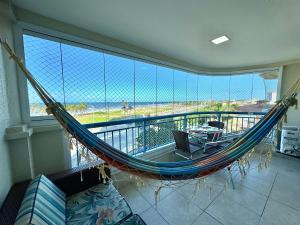 a hammock in a balcony with a view of the ocean at AllMar Flats - Apartamentos frente mar - Beach Village in Fortaleza