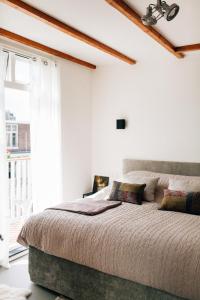 a bedroom with a large bed and a window at Boutique B&B Bovien in Amsterdam