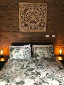 een slaapkamer met een bed met 2 kussens en een muur bij Sailz Villas in Yarrawonga
