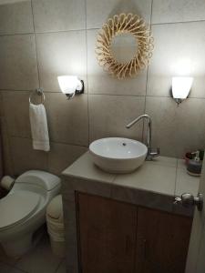 y baño con lavabo, aseo y espejo. en Urban Home, en Guatemala