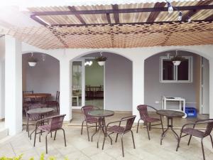 a patio with tables and chairs under a roof at Urban Home in Guatemala