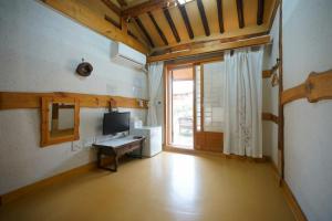 a room with a desk and a television and a window at Hanok Madang in Jeonju
