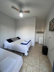 阿图尔诺盖拉Quarto de Casal Pousada Dos Ypês的带两张床和吊扇的卧室
