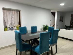 a dining room with a table and blue chairs at Espectacular casa para la Exponor in Antofagasta +5 photos
