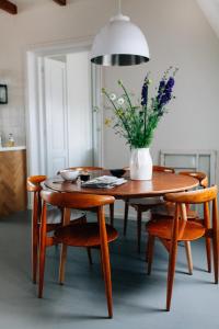 a dining room table with a vase of flowers on it at Boutique B&B Bovien in Amsterdam +22 photos