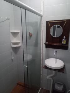 a bathroom with a glass shower and a sink at Casa térrea no centro próximo a praia! in Balneário Camboriú