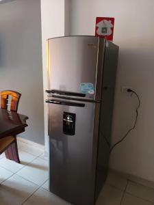 um frigorífico de aço inoxidável numa cozinha ao lado de uma mesa em Casa Hamburgo em Pereira