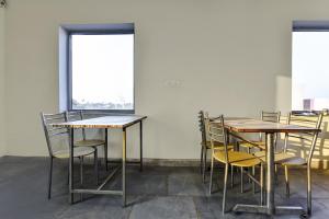 ein Zimmer mit Tischen und Stühlen und einem Fenster in der Unterkunft OYO Hotel Ishwar in Jaipur