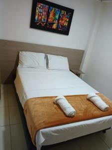 Una cama en una habitación con dos toallas. en Casa Hamburgo en Pereira