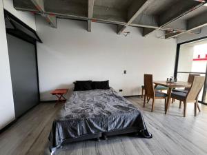 a bedroom with a bed and a table with chairs at Cercano al Aeropuerto y nuevo in Pereira +15 photos