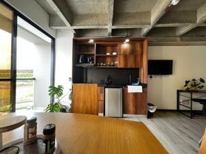 a kitchen with wooden cabinets and a table in a room at Cercano al Aeropuerto y nuevo in Pereira