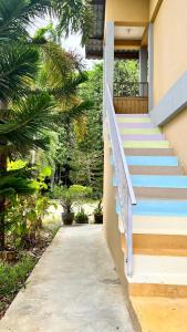 Una escalera que conduce a una casa con escaleras azules en Country house Pulai Holiday Village, en Gua Musang