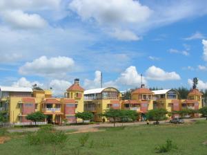 a row of yellow and red apartment buildings at Palmyrah Tenements in Mysore