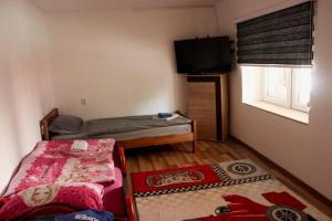 a small room with two beds and a flat screen tv at Vista Sarajevo Old Town in Sarajevo