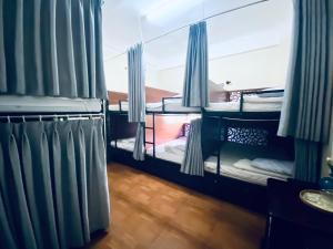 Pokój z 2 łóżkami piętrowymi i niebieskimi zasłonami w obiekcie Hong My Hotel w mieście Kon Tum (2)