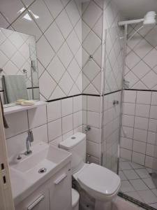 a white bathroom with a toilet and a sink at Apartamento aconchegante in Brasília