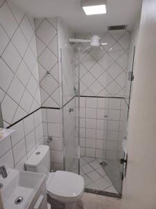 a bathroom with a shower with a toilet and a sink at Apartamento aconchegante in Brasília