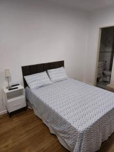 a bedroom with a bed with a white comforter at Apartamento aconchegante in Brasília