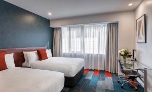 a hotel room with two beds and a window at Rydges Auckland in Auckland