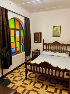 um quarto com uma cama e um vitral em Casa Grande Hostal em Medellín