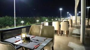 a table and chairs on a balcony at night at Five Seasons Hotel in Tabuk