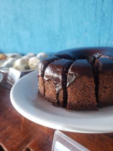 a chocolate cake on a plate on a table at Pousada Recanto Rainha do Lago in Capitólio