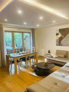 a living room with a table and a couch at Luxe et calme à 7 mns de Paris in Courbevoie