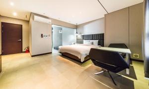 ソウルにあるYeongdeungpo Lifestyle F Hotelのベッドルーム1室(ベッド1台、デスク、椅子付)