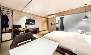 Habitación de hotel con cama y silla en Yeongdeungpo Lifestyle F Hotel en Seúl