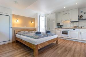 a bedroom with a bed in a kitchen with white cabinets at Huus Avelia Appartement DG in Böhl