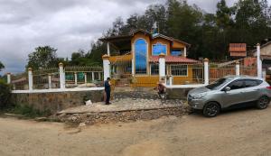 un hombre parado frente a una casa con un coche en Casa de campo Sueño Amatista, en Gachetá