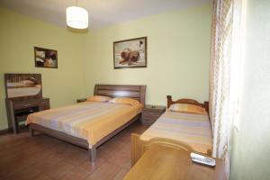 1 Schlafzimmer mit 2 Betten und einem Tisch in der Unterkunft Alen Bar Hotel in Tirana