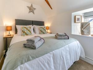 1 dormitorio con 1 cama blanca grande y toallas. en Chapel View, en Brentor