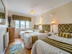 een hotelkamer met 2 bedden en een raam bij Tigh Na Beannaich in Powmill